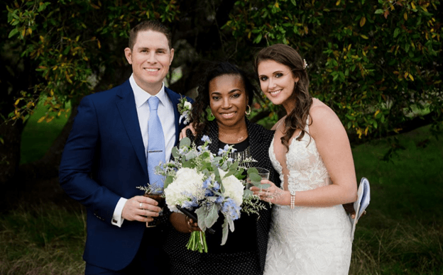 Bride and groom posing with their wedding planner