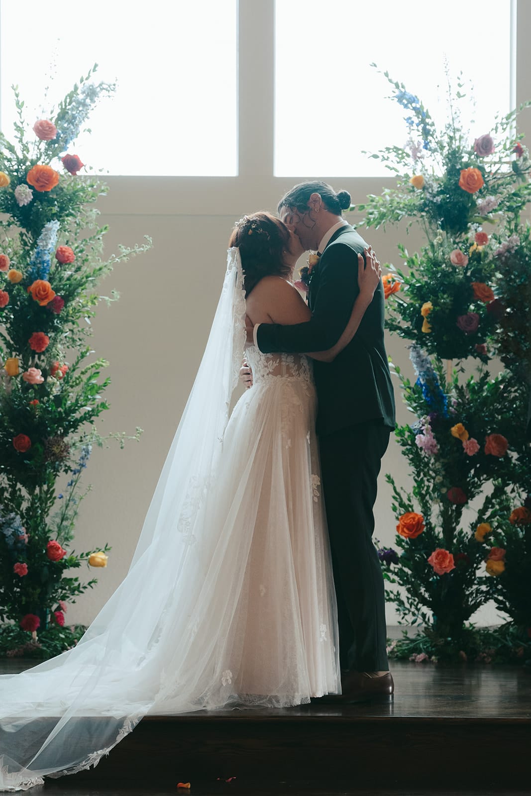 Bride and groom at the altar between floral columns