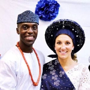 Bride and groom in Nigerian wedding attire, the groom in white with coral beads